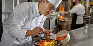 A chef preparing a dish in a restaurant kitchen.